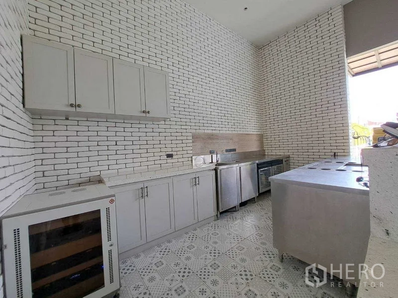 Retail Space for rent in Watthana, Bangkok - Built-in cabinets and undercounter fridges in a high-ceiling white brick kitchen.
