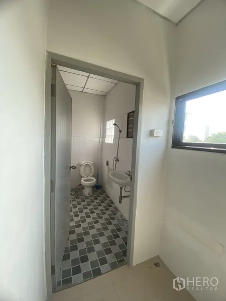 联排别墅 出租在Suan Luang, Bangkok - 紧凑卫生间，配淋浴、坐便与台盆，棋盘格地砖并设窗户通风。