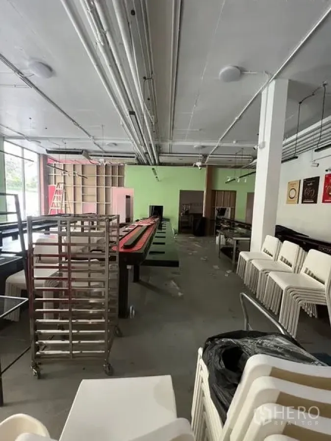 Retail Space for rent in Huai Khwang, Bangkok - Wide retail hall with shelving, stainless racks and ceiling utilities ready for fit-out.
