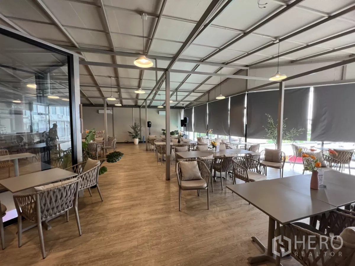 Retail Space for rent in Khlong Toei, Bangkok - Panoramic view of bright dining area with many tables, large windows with blinds and indoor plants.