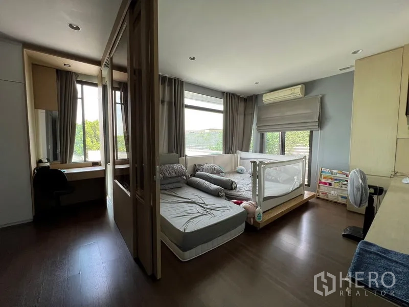 Detached House for sale in Bang Kapi, Bangkok - Corner bedroom with big windows, built-in desk and wardrobes.