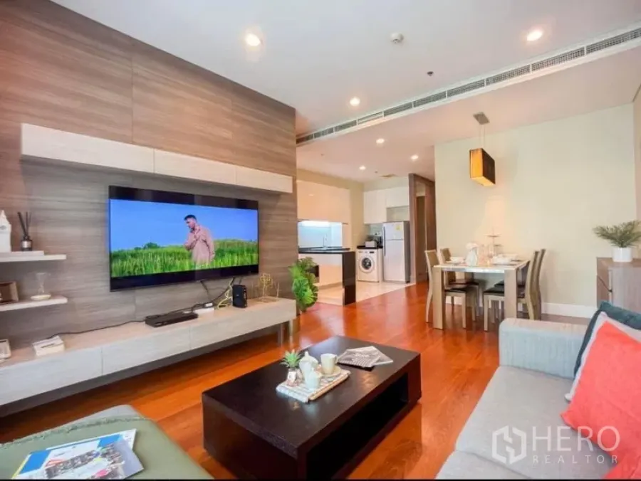 Condominium for rent in Khlong Toei, Bangkok - Another angle of the living room featuring a floating TV wall, sofa and dining nook.
