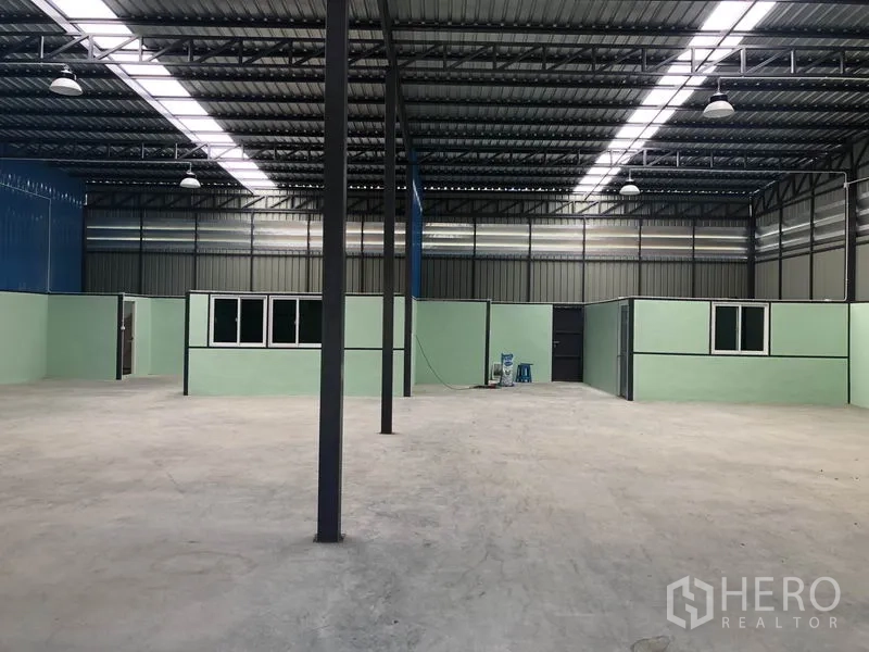 Warehouse for rent in Khlong Luang, Pathum Thani - Open-plan 400 sqm floor with partitioned mint-green offices and windows under bright lighting.