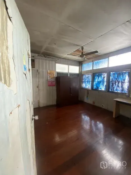 独立式住宅 出租在Khlong Toei, Bangkok - 室内空房，木地板、吊扇与大窗户，适合翻新