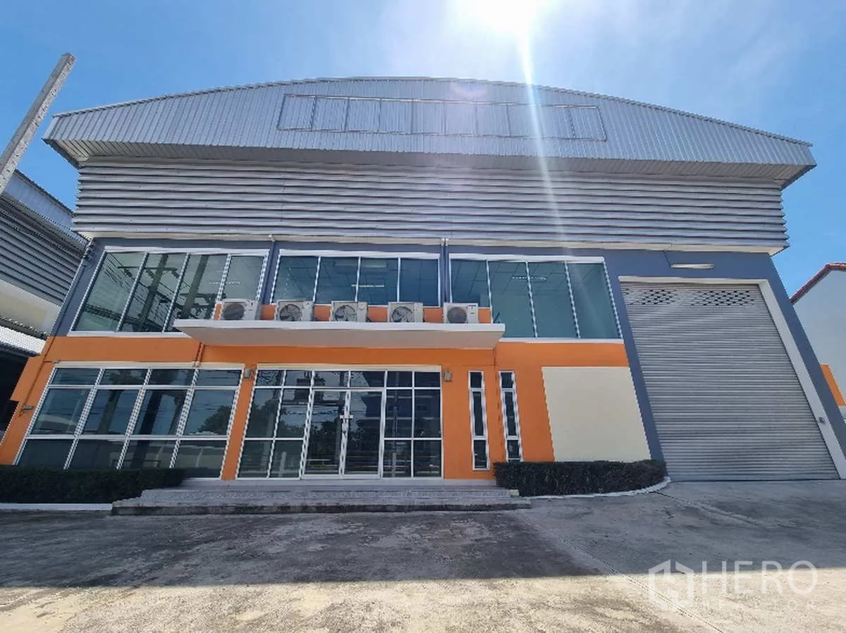 Factory for rent in Samut Prakan - Front elevation showing the two-storey office with AC units and a wide entrance.