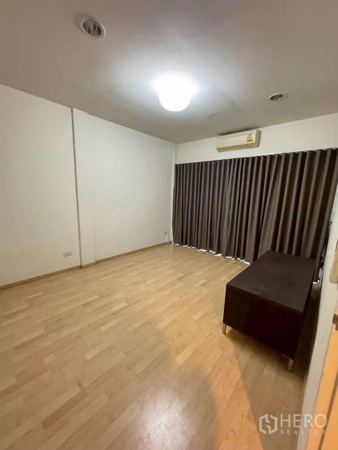 Townhouse for rent in Suan Luang, Bangkok - Large bedroom with wood floors, blackout curtains and air-conditioner.