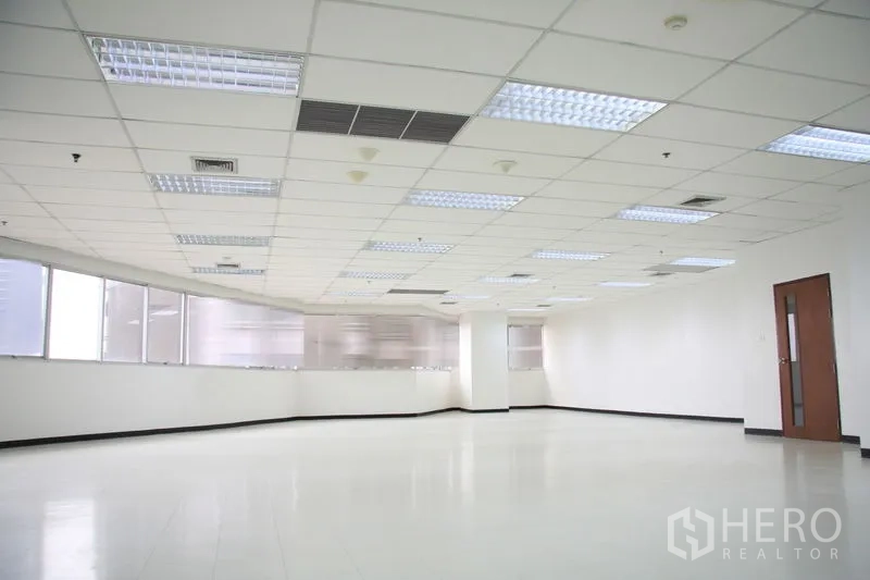 Office Space for rent in Chatuchak, Bangkok - Open-plan office corner with door, column, ceiling lights, and air-conditioning vents.
