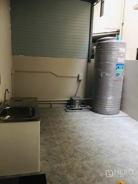 Home Office for rent in Wang Thonglang, Bangkok - Outdoor utility area with sink, large water tank and pump on tiled flooring.