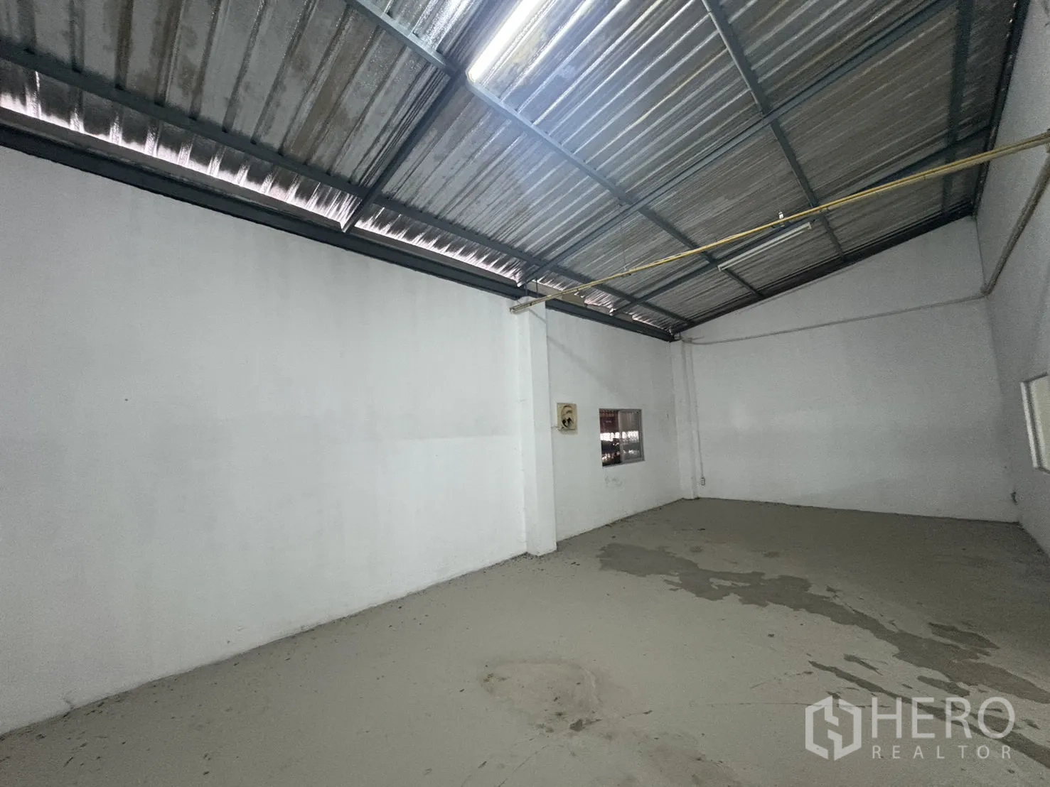 Warehouse for rent in Bang Phli, Samut Prakan - Mezzanine storage room with sloped metal roof and small window.