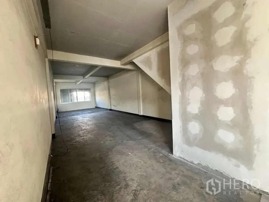 Office Space for rent in Phra Khanong, Bangkok - Open-plan office interior with concrete floor, light walls, ceiling beams and a rear window.