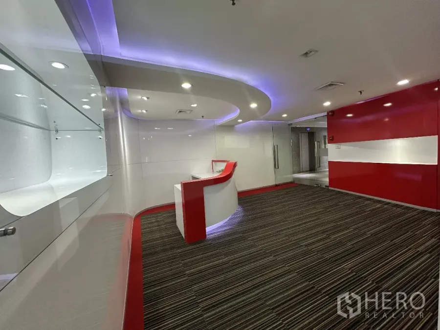 Office Space for rent in Watthana, Bangkok - Modern reception area with curved red-and-white desk, glass entry and LED ceiling lights.