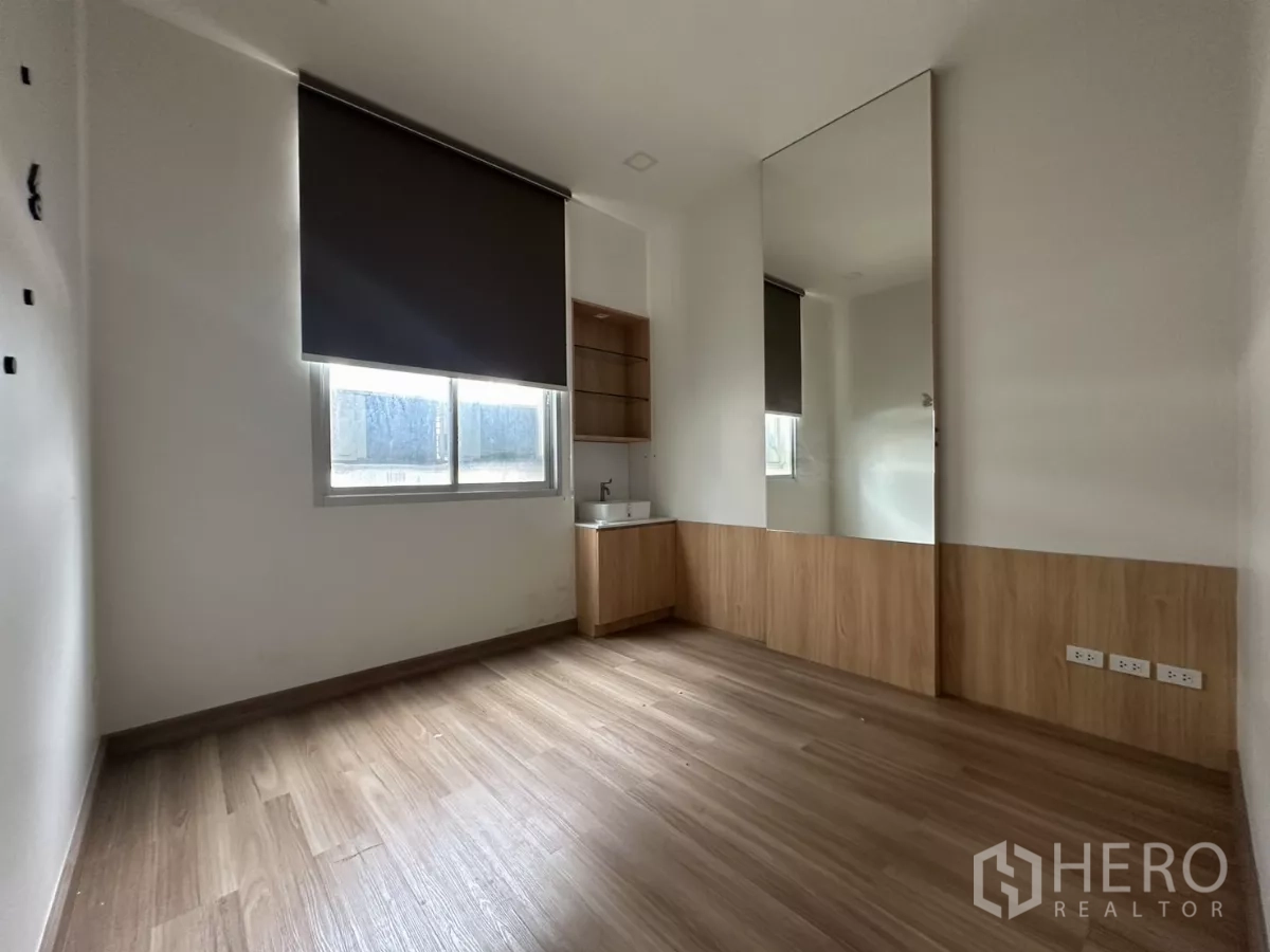 Retail Space for rent in Phra Khanong, Bangkok - Spacious room with wood floors, corner sink, large mirror and window shading.
