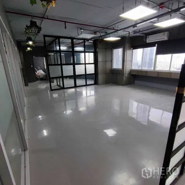 Office Space for rent in Watthana, Bangkok - Long room with shiny flooring, grid-glass meeting room enclosure and multiple windows.