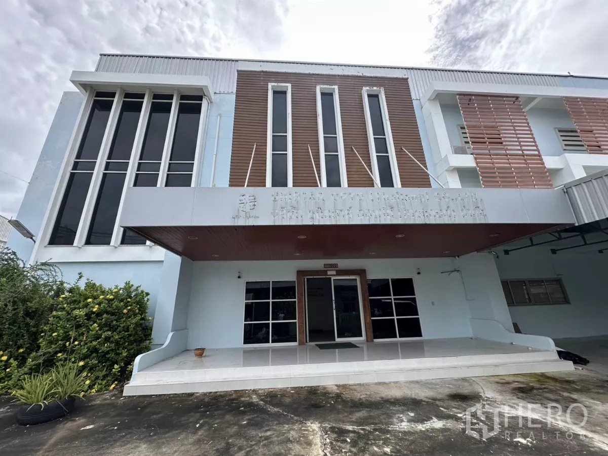 Factory for rent - Main entrance facade with tall glass windows and wood accents under a canopy.