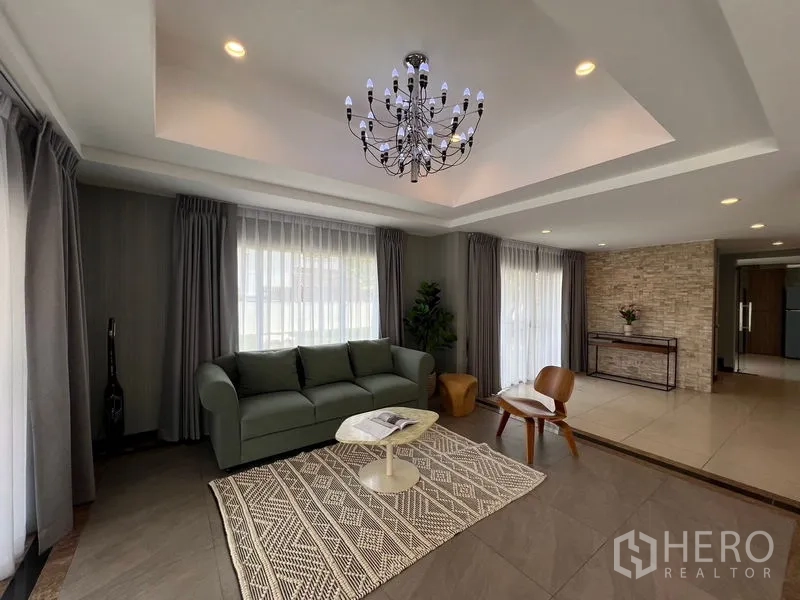 Detached House for sale in Mueang Pathum Thani, Pathum Thani - Alternate angle of the living room highlighting tray ceiling and stone accent wall.