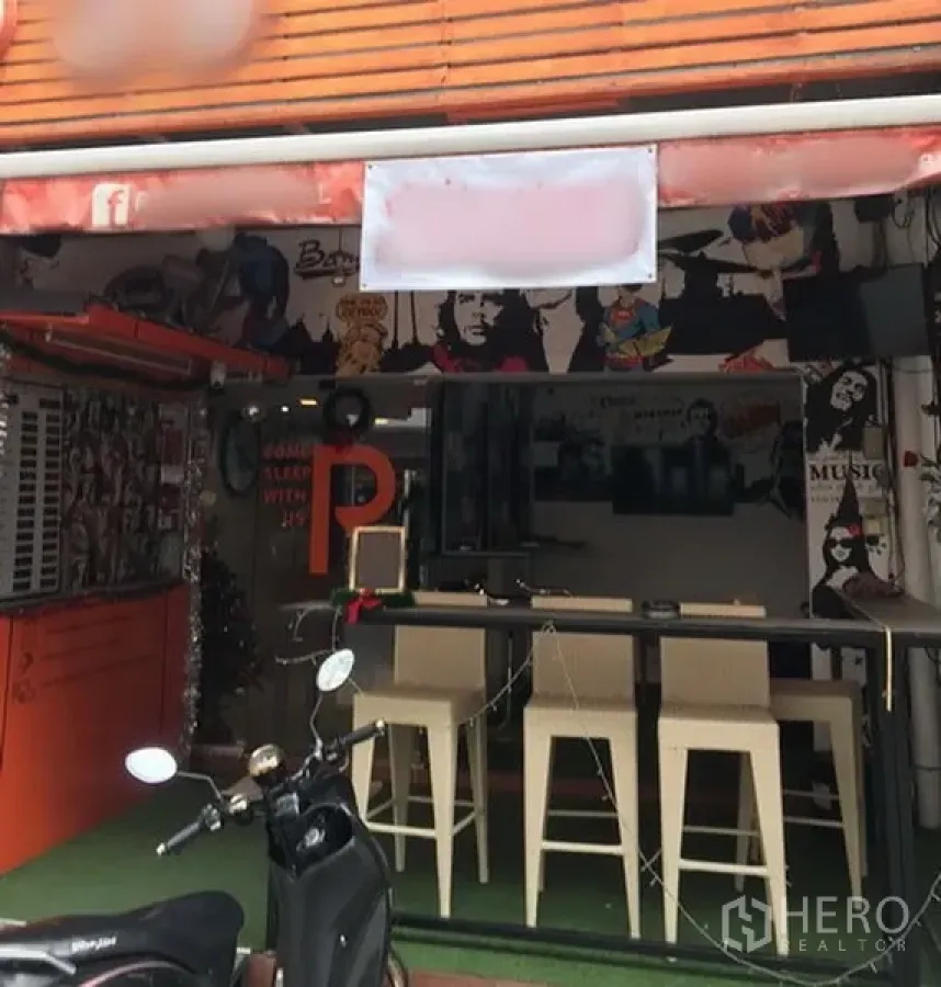 Retail Space for rent in Watthana, Bangkok - Street‑front retail shop with orange awning, glass frontage, high counter and stools, pop‑art murals near Phrom Phong BTS.