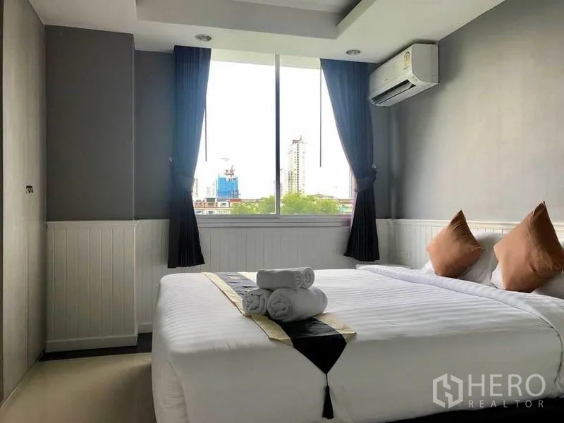 Condominium for rent in Khlong Toei, Bangkok - Second bedroom with double bed, air conditioner and large window.