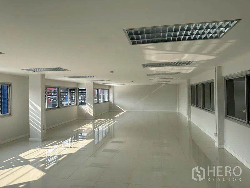 Factory for rent in Bang Phli, Samut Prakan - Bright second-floor office with tiled flooring, grid lighting and rows of windows.
