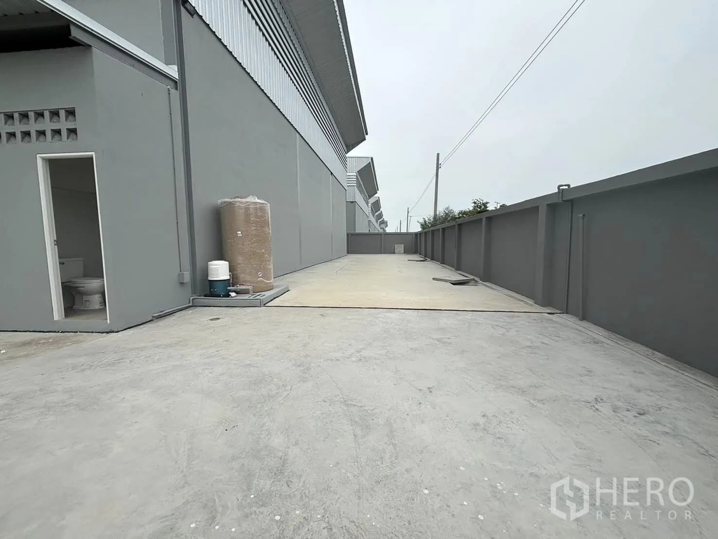 工厂 出租或出售在Bang Bo, Samut Prakan - 后方混凝土作业场地，围墙及侧门相连工厂。