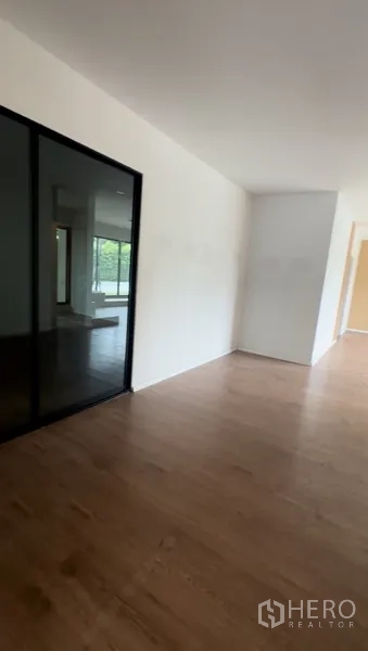 Retail Space for rent in Bang Na, Bangkok - Corridor leading to additional retail area with white walls and wood flooring.