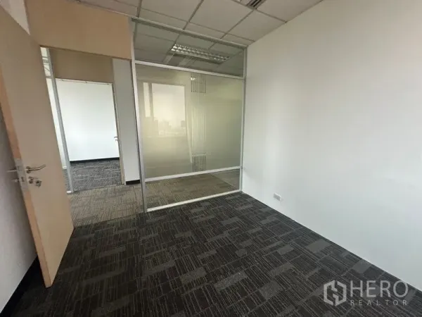 Office Space for rent in Khlong Toei, Bangkok - Small office room with frosted glass partition and drop ceiling lighting.