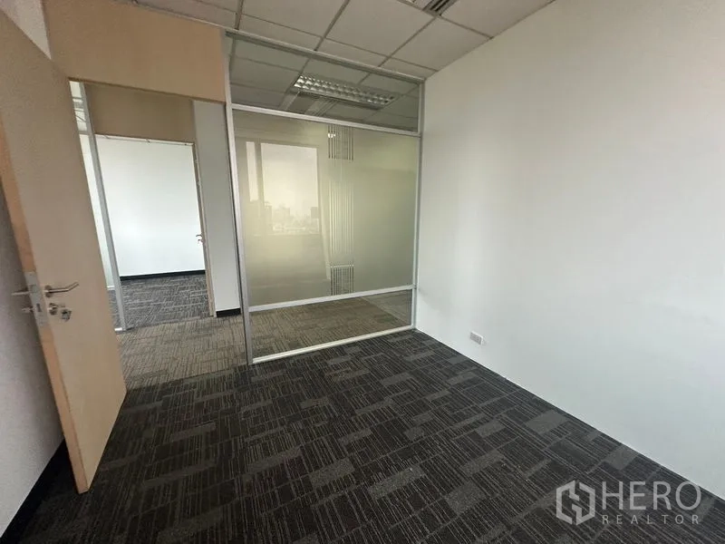 Office Space for rent in Khlong Toei, Bangkok - Small office room with frosted glass partition and drop ceiling lighting.