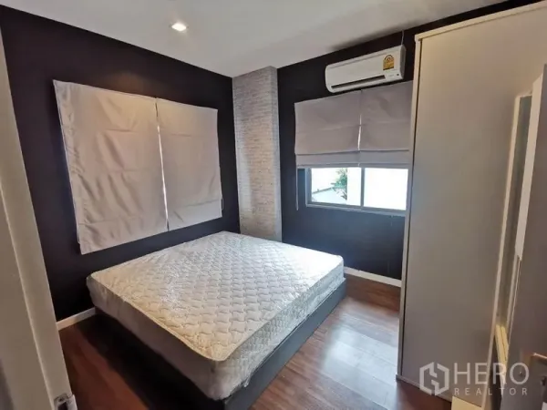 Detached House for rent in Prawet, Bangkok - Cozy second bedroom with bed, air conditioner, dark accent wall and window.