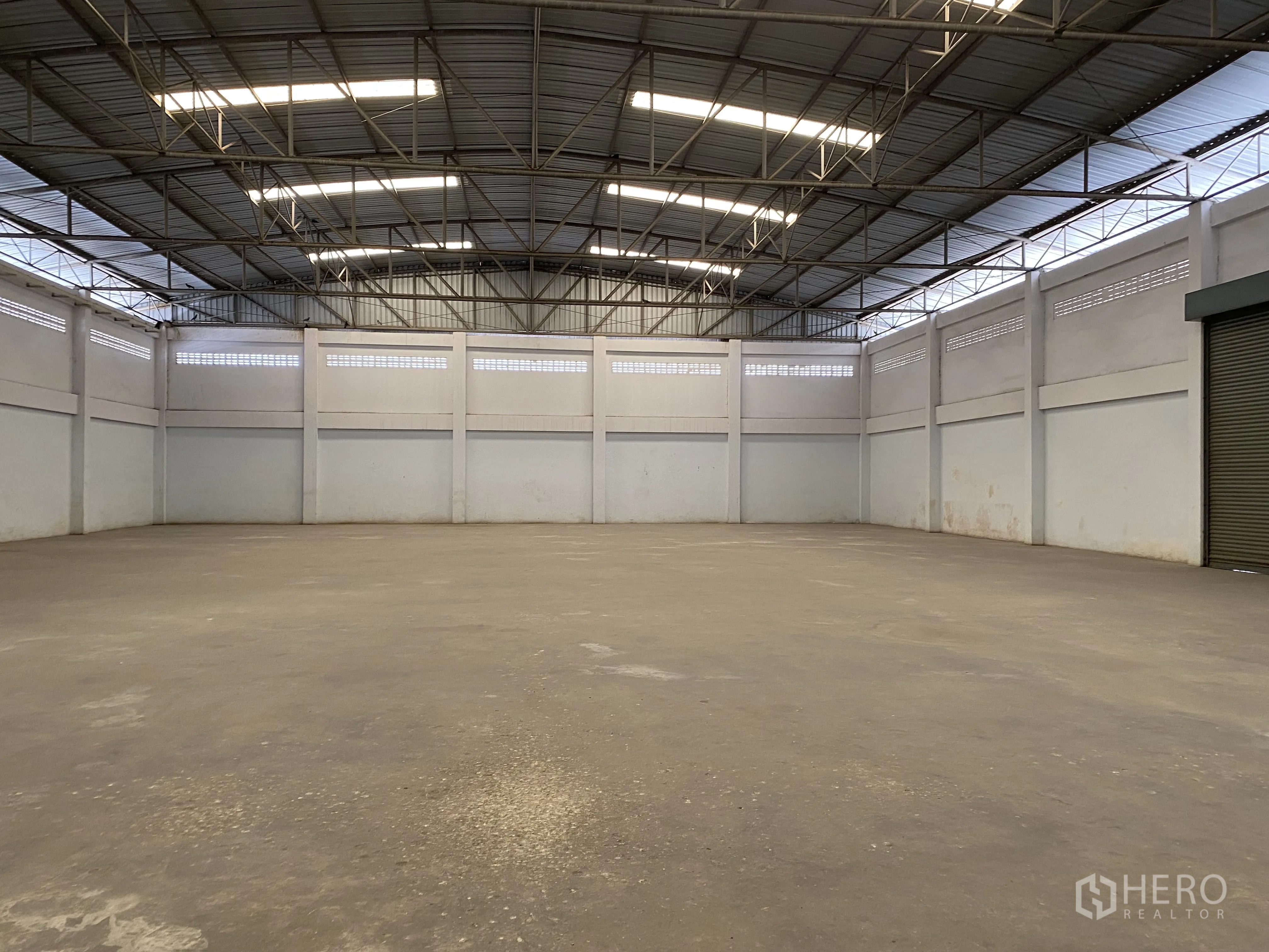 工厂 for sale in Khlong Luang, Pathum Thani - 大型仓库内部，高钢桁架屋顶与天窗采光。