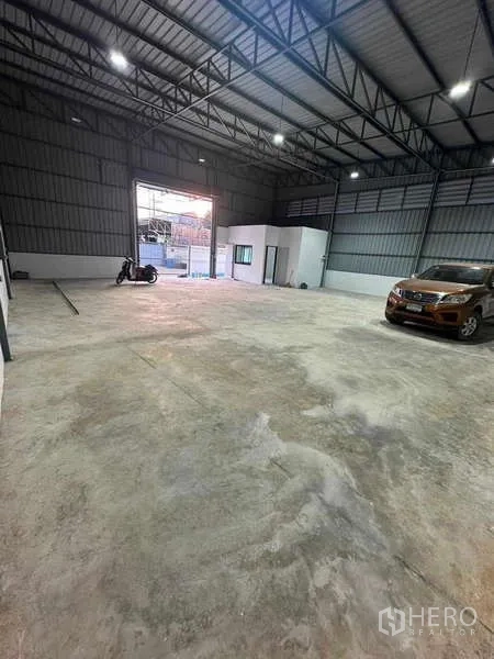 Warehouse for rent in Bang Khen, Bangkok - Open-plan warehouse floor with high ceiling, LED lighting and wide front opening for vehicle access.