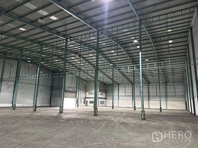 Warehouse for rent in Mueang Samut Prakan, Samut Prakan - Interior showing a grid of steel columns, insulated metal roof and expansive clear-span storage area.