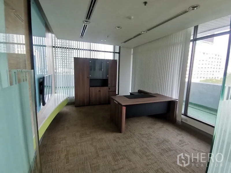 Office Space for rent in Bang Rak, Bangkok - Executive office with desk and cabinet, floor-to-ceiling windows and balcony access.