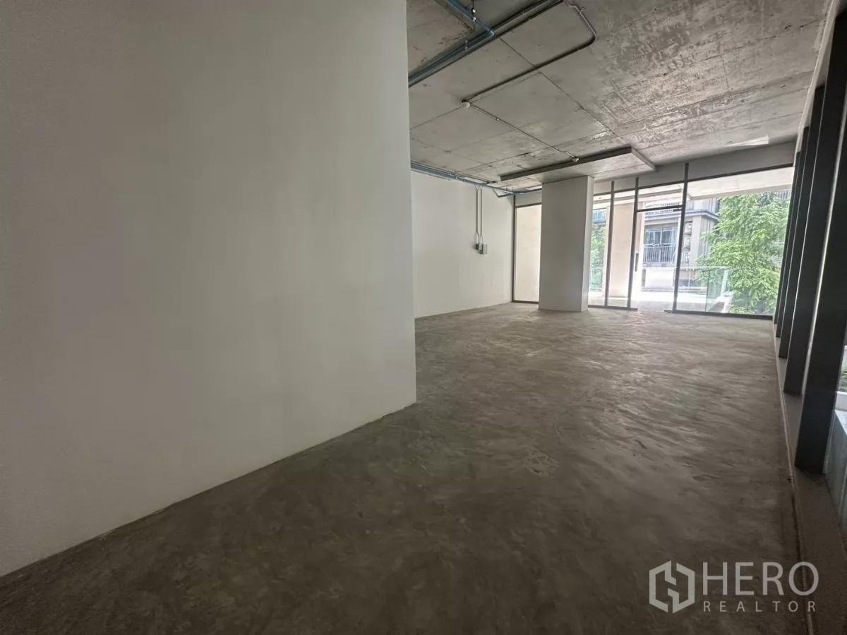 Retail Space for rent - Unfurnished 90 sq m interior with exposed ceiling and floor-to-ceiling windows, ideal for showroom or office.