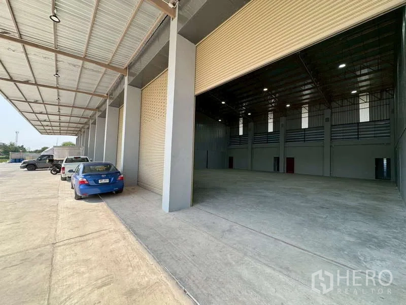 Warehouse for rent in Bang Phli, Samut Prakan - Covered loading bay with multiple roll-up doors and a wide driveway at a modern warehouse in Bang Phli