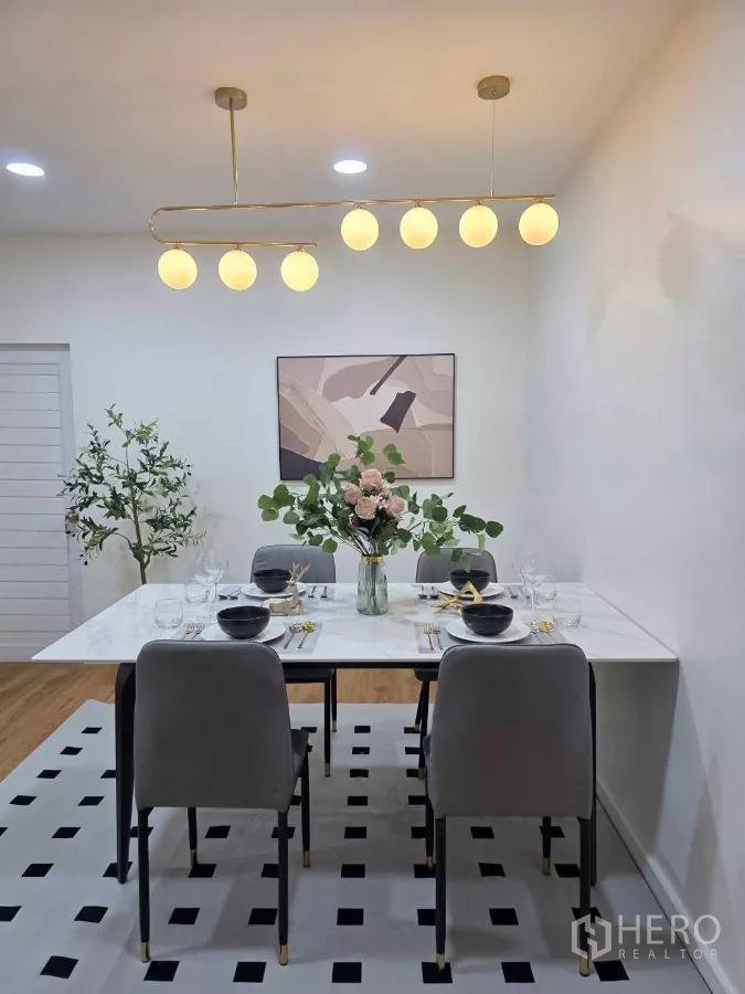 Detached House for rent in Huai Khwang, Bangkok - Elegant dining room with marble table, six chairs and a globe chandelier.