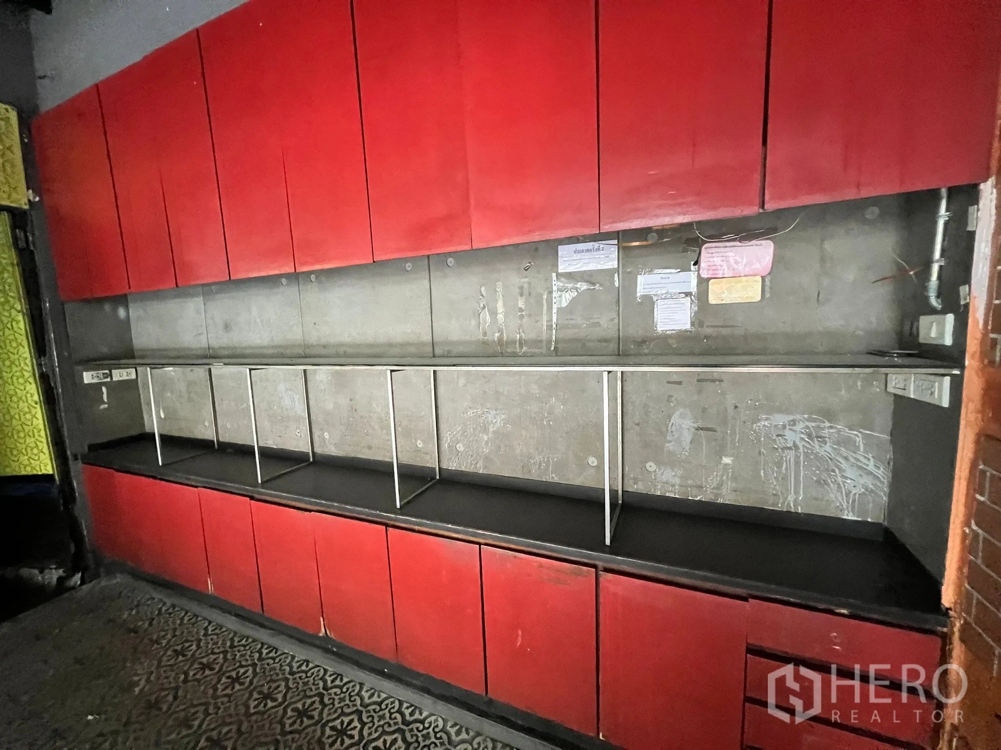 Retail Space for rent in Watthana, Bangkok - Built-in red storage cabinets with open display shelves against a concrete wall.