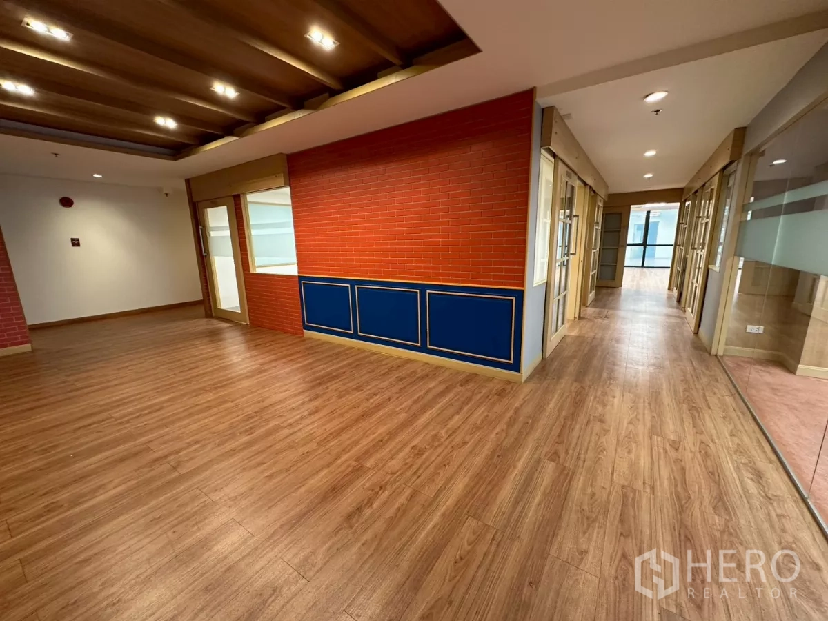 Office Space for rent in Khlong Toei, Bangkok - Lobby area with wood ceiling beams, red brick accent wall, and blue paneling.