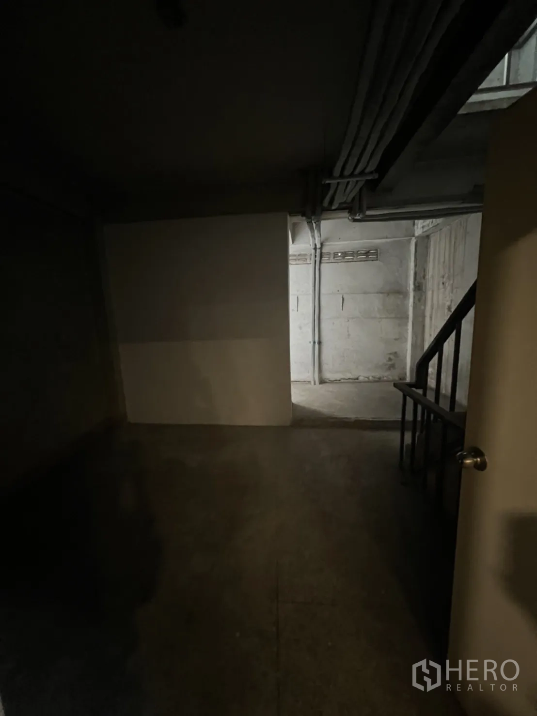 Shophouse for rent in Phra Khanong, Bangkok - Basement storage area with concrete walls and stair access.