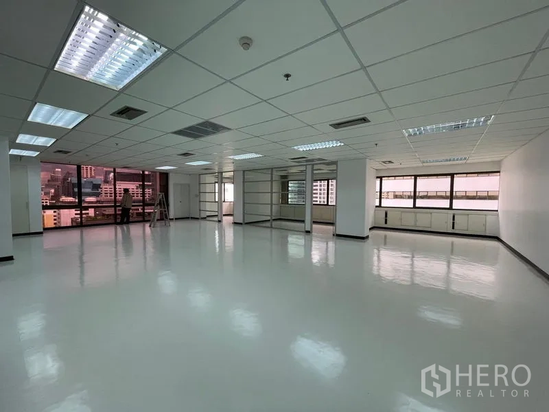 Office Space for rent in Bang Rak, Bangkok - Wide open office space with multiple windows and shelving partitions.
