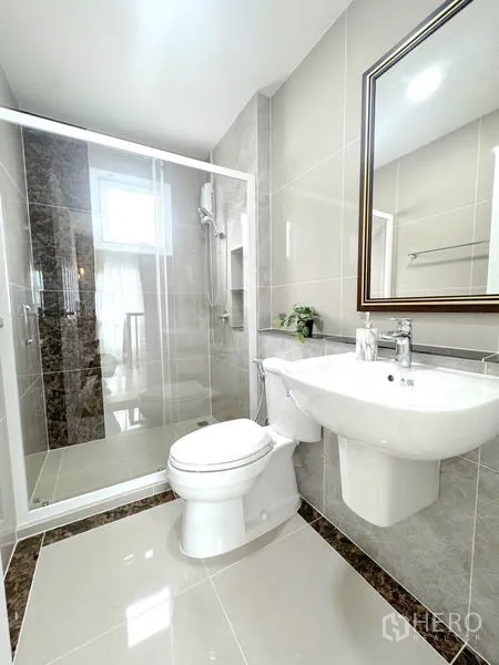 Detached House for rent - Modern bathroom with glass shower enclosure, toilet and sleek tiling.