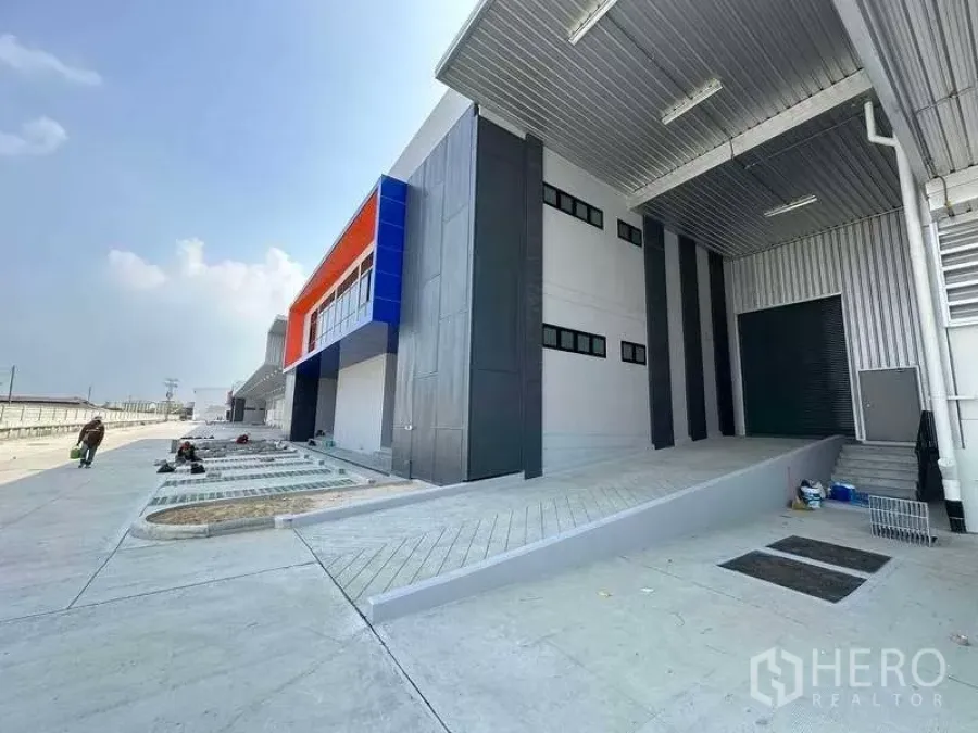 Warehouse for rent in Chon Buri - Modern warehouse exterior in Si Racha with covered loading ramp and colorful facade in a Free Trade Zone.