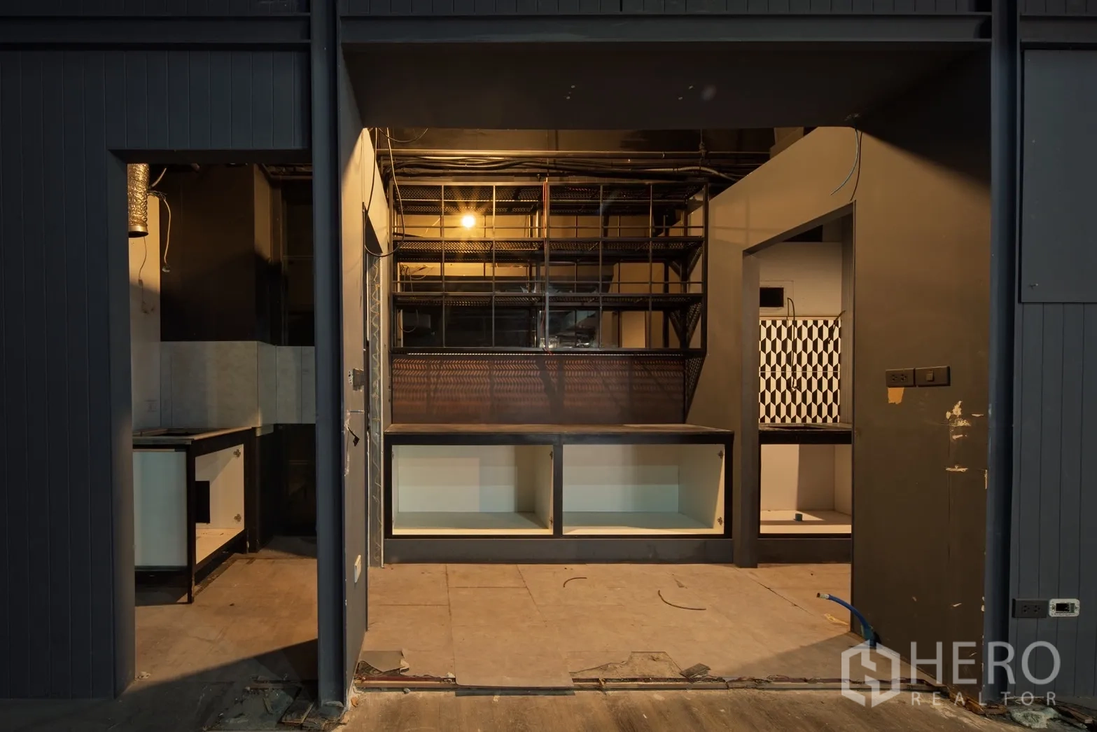 Retail Space for rent in Watthana, Bangkok - Front counter with metal shelving and checkered-tile back room ready for fit-out.