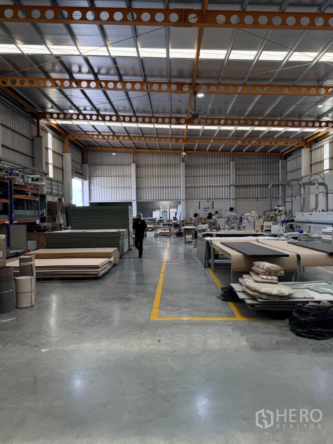 Factory for rent or sale in Lam Luk Ka, Pathum Thani - Open manufacturing space with central aisle and stacked materials.