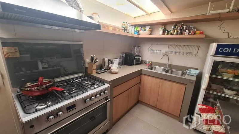 Detached House for rent in Watthana, Bangkok - Functional kitchen with gas range, hood and double sink.