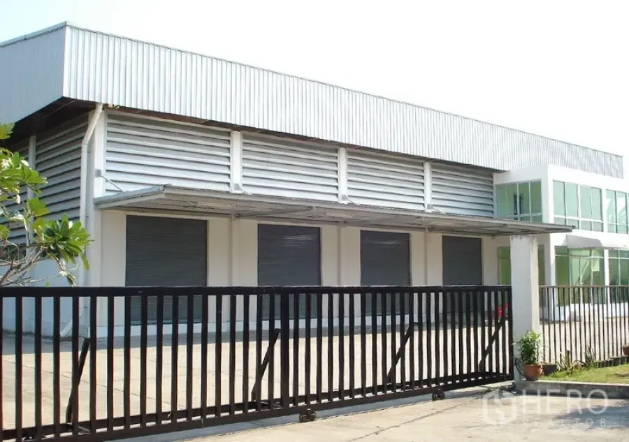 货栈 出租在Samut Prakan - 仓库外观，带大门与多扇卷闸门、遮篷和通风百叶，位于邦普里。
