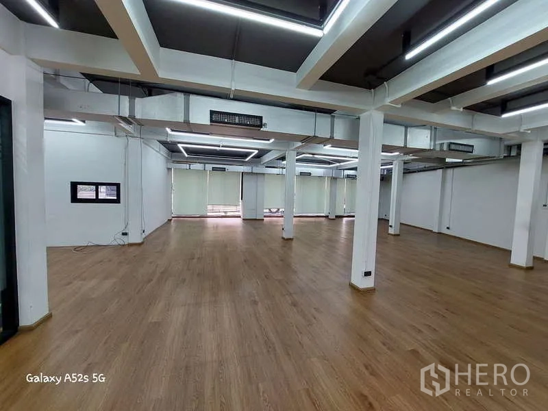 Office Space for rent in Khlong Toei, Bangkok - Wide office floor with multiple pillars, LED strip lighting and light-filtering blinds.