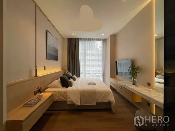 Condominium for rent or sale in Pathum Wan, Bangkok - Cozy bedroom with king bed, built-in headboard lighting, wall-mounted TV and full-height window.