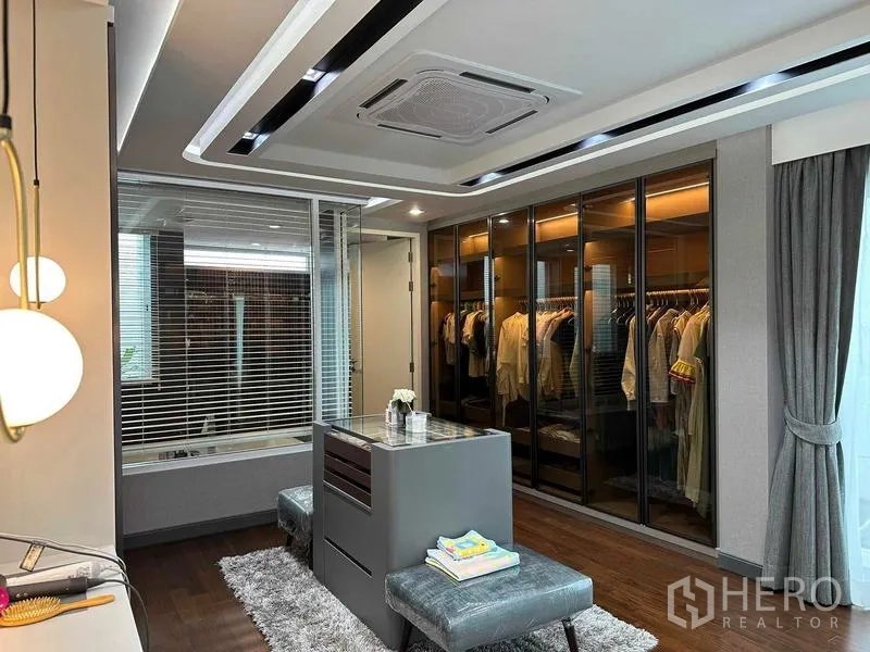 Detached House for sale in Suan Luang, Bangkok - Walk-in closet with glass wardrobes, island dresser and ceiling cassette air conditioner.