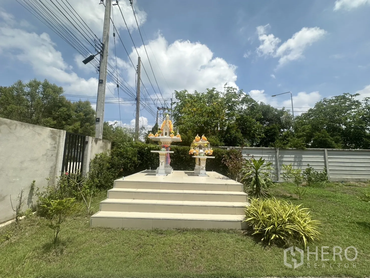 Warehouse for sale in Bang Len, Nakhon Pathom - Raised spirit house shrine set in a grassed garden by the entrance.