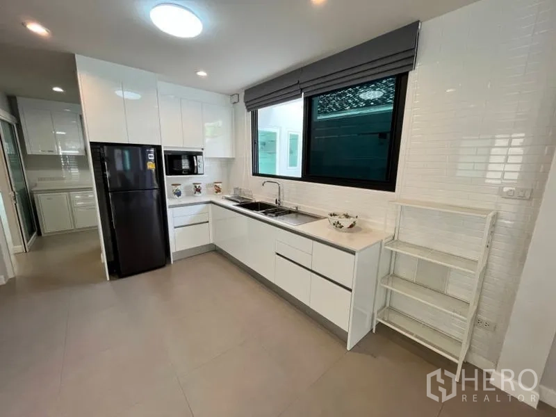 Detached House for rent in Phaya Thai, Bangkok - Another view of the main kitchen with black fridge and microwave.