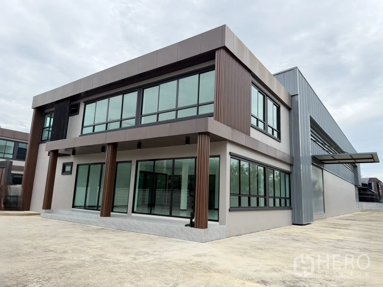 工厂 for sale in Bang Len, Nakhon Pathom - 两层玻璃立面的办公楼与厂房相连的外观。